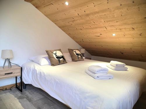 Cette chambre comprend 2 lits jumeaux dans un plafond en bois. dans l'établissement Chalet des Jonquilles - Au calme, bordant la forêt, à Gerbépal