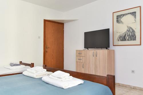 a room with two beds and a tv on a wall at Apartments Milos Kaladjurdjevic in Budva