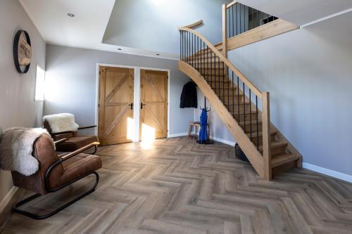 a living room with a staircase and a chair at Jantje Slot Hoeve aan de rand van Lemmer in Oosterzee