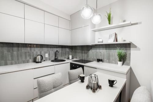a white kitchen with white counters and white cabinets at Good Times Luxury Apartments Bitola in Bitola