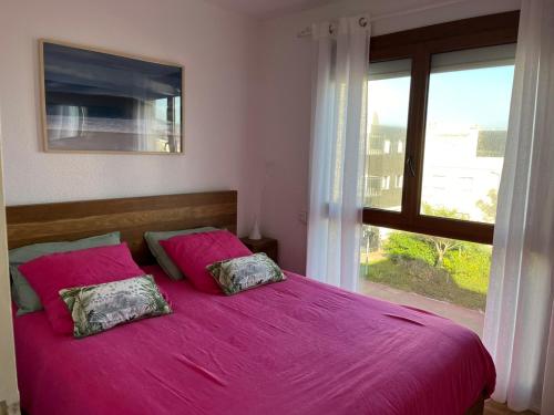 a bedroom with a pink bed with a window at Prestige Ocean Apartment - 50 m2 - 2 chambres in Lacanau