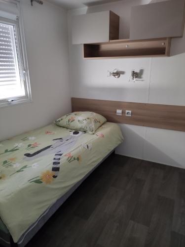 une petite chambre avec un lit et une fenêtre dans l'établissement Mobil-home 6/8 personnes au Domaine de Kerlann, Pont-Aven, à Pont-Aven