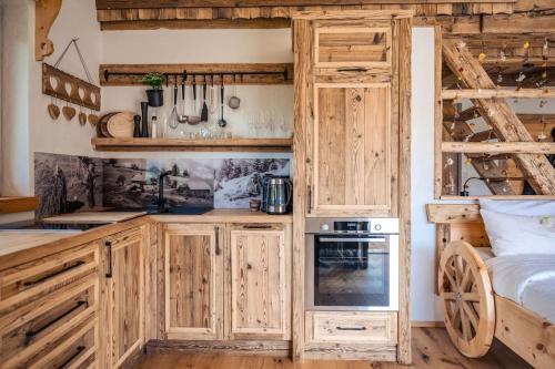 eine Küche mit Holzschränken und ein Bett in einem Zimmer in der Unterkunft Unterkircher Chalet in Arriach