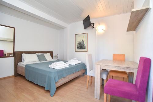 a bedroom with a bed and a table and a chair at Apartments Milos Kaladjurdjevic in Budva