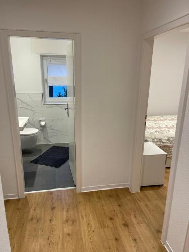 Klein aber fein — citynah في أونا: حمام ابيض مع مرحاض ونافذة