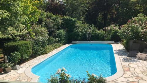 a swimming pool in the middle of a garden at La Roseraie in Tournai