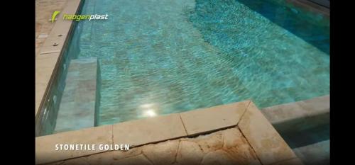 a large swimming pool with water in it at Kapetanios Luxury in Agios Georgios