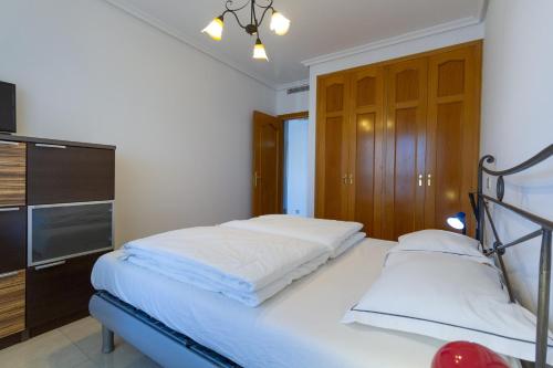 a bedroom with two beds and a flat screen tv at Amazing apartments in the modern Coruña building, near the beach, pool & garage in Villajoyosa