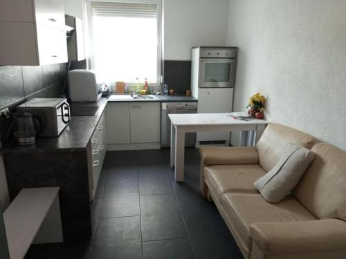 a living room with a couch and a kitchen at Lara Zimmer in Heilbronn Zentrum in Heilbronn
