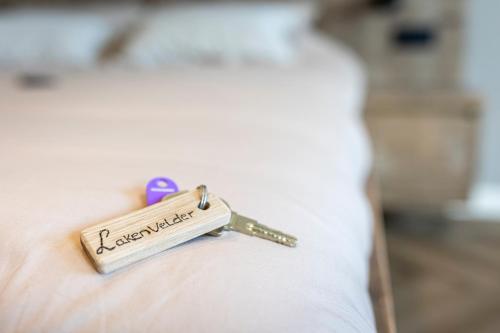 a key to a bed with the word excellence on it at Jantje Slot Hoeve aan de rand van Lemmer in Oosterzee