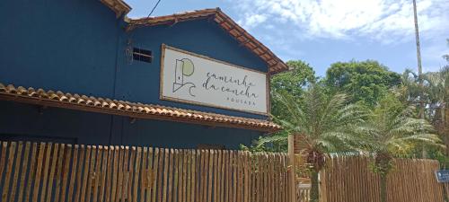 a sign on the side of a blue building at Pousada Caminho da Concha in Itacaré