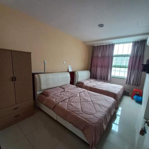 a bedroom with two beds and a dresser at EASY HOMESTAY LUKUT NS in Port Dickson