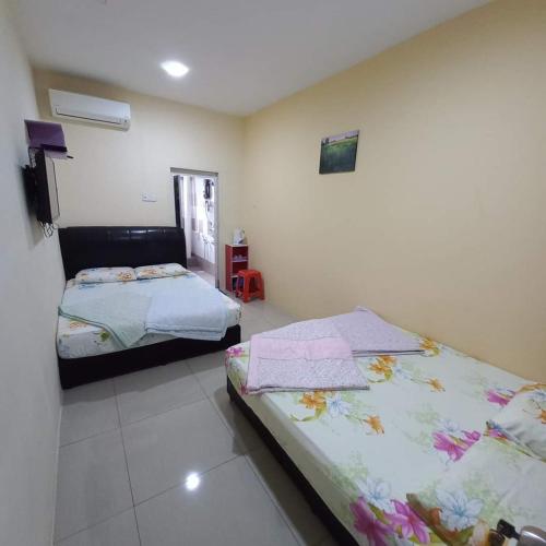a bedroom with two beds in a room at EASY HOMESTAY LUKUT NS in Port Dickson