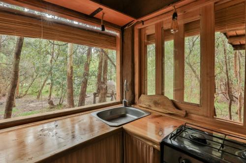 a kitchen with a sink and two windows at Casa de barro in Santa Ana