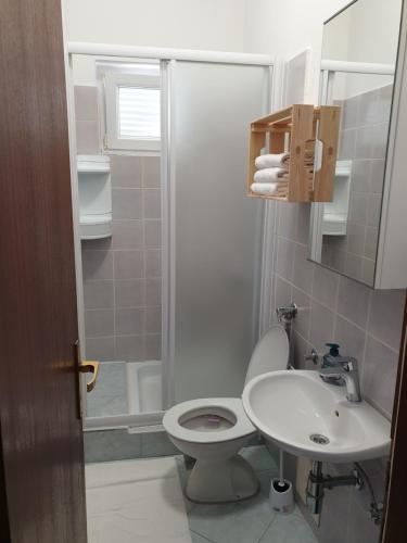 a bathroom with a toilet and a sink and a shower at Soba brez balkona in Stara Novalja
