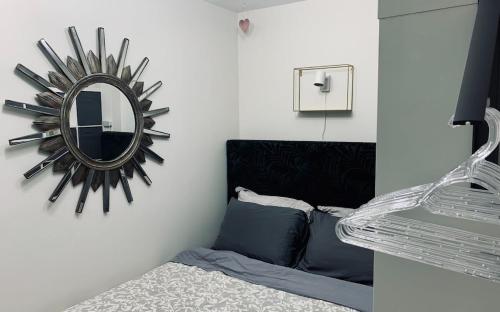 um espelho pendurado numa parede ao lado de uma cama em Ultimate Pet-friendly Studio #1, Patio em Halifax