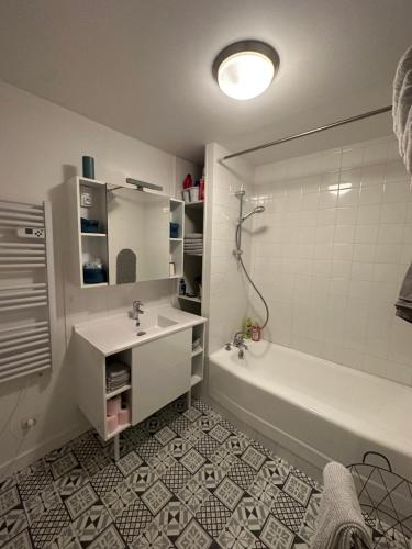 a bathroom with a white tub and a sink and a bath tub at 2 chambres, 4 a 6 voyageurs en centre ville, à 5 mins du zoo in La Flèche