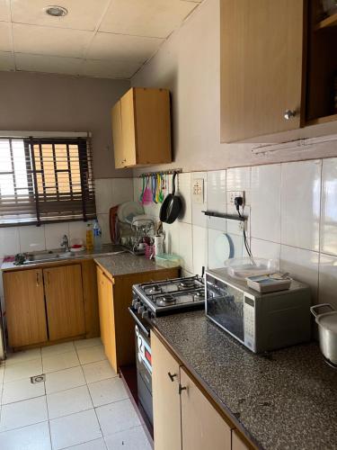 a kitchen with a stove and a counter top at OD-V!CK'S BUDGET ROOMS, 24HR POWER, SECURITY, DSTV in Abuja