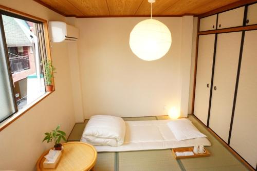 大阪市にあるSYOGA A house, next to natural parkのベッドとテーブル付きの小さな部屋