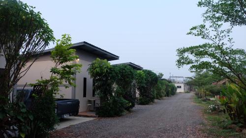 a road next to a house with trees at เช็คอินรีสอร์ทชัยนาท Check-in resort in Ban Khao Khayai (1)