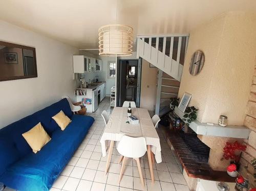 un salon avec un canapé bleu et une table dans l'établissement Charment Cottage de 45 m2 Rénové et moderne, à Villers-sur-Mer
