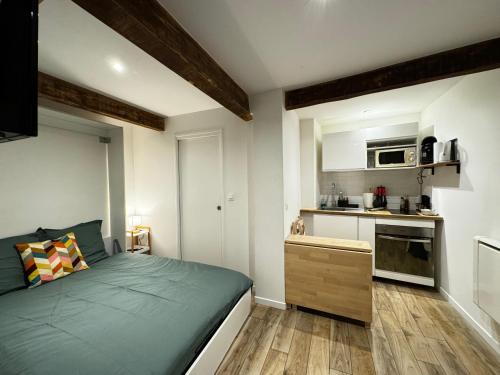 une petite chambre avec un lit et une cuisine dans l'établissement Le Pétramale - Cœur de ville - Navette Parking, à Avignon