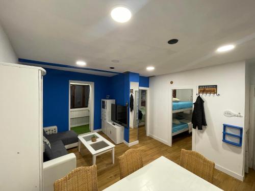 a living room with blue walls and a table and chairs at La Casa del Capitán in Ribadesella