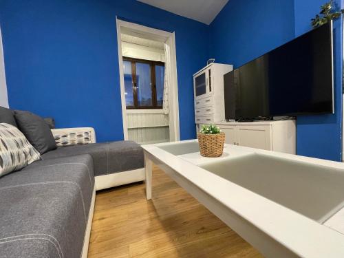 a living room with a couch and a flat screen tv at La Casa del Capitán in Ribadesella