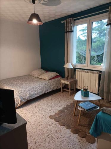 une chambre avec un lit, une table et une fenêtre dans l'établissement Chambre d'hôtes les garrigues, à Piolenc