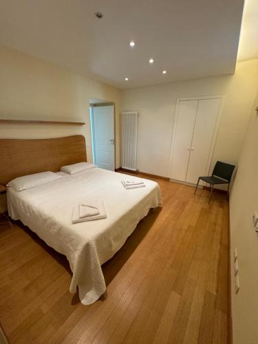 a bedroom with a large white bed and a chair at Appartamenti Michela in Camogli