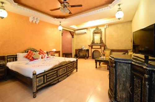 a bedroom with a large bed and a fireplace at CHOKHI DHANI INDORE in Indore