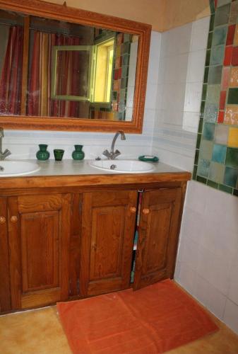 une salle de bain avec un lavabo et un miroir dans l'établissement Petit mas en pays de l'Uzège, à Saint-Jean-de-Ceyrargues