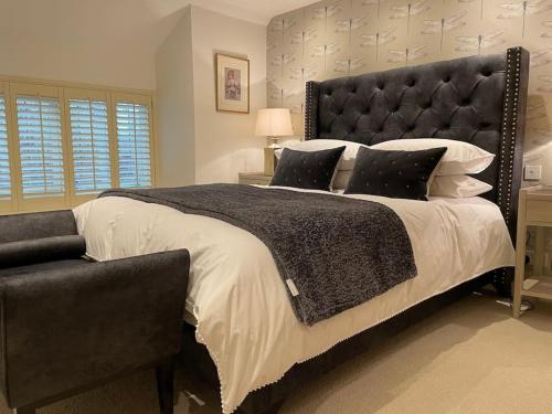 a bedroom with a large bed with a black headboard at Beautiful Baslow Bolthole (close to Chatsworth) in Baslow