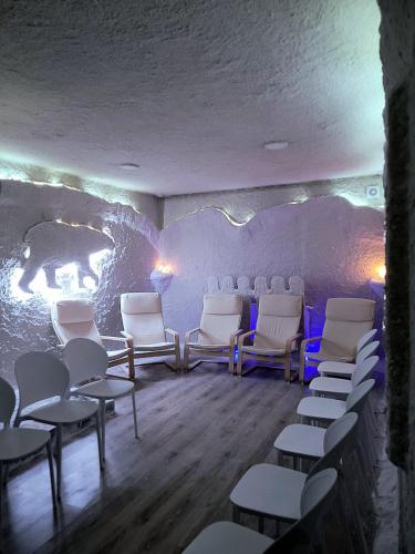 a room with white chairs and a wall with a bear mural at SPA Resort HeRICH in Bukovel