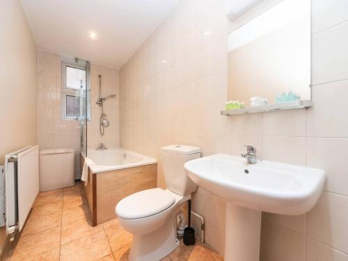 ein Bad mit einem WC und einem Waschbecken in der Unterkunft Garden Flat With a Heath Views & London Skyline in London