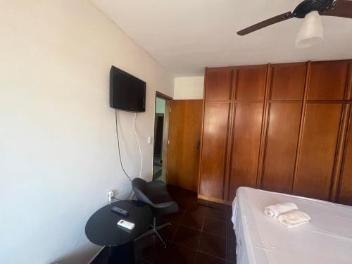 a bedroom with a bed and a chair and a tv at Local privilegiado no Bueno com Ar Tv e banheiro privativo! in Goiânia