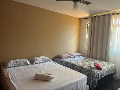 1 dormitorio con 2 camas y ventilador de techo en Local privilegiado no Bueno com Ar Tv e banheiro privativo!, en Goiânia
