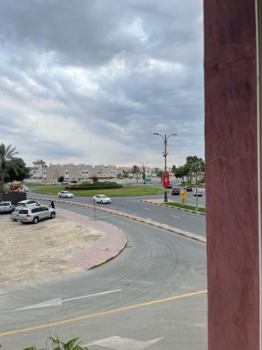 a street with cars parked on the side of a road at Corniche Palace Hotel in Ajman 
