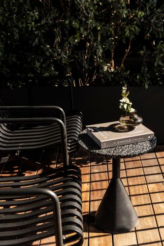 a table with a book on it next to a chair at The Modernist Athens in Athens
