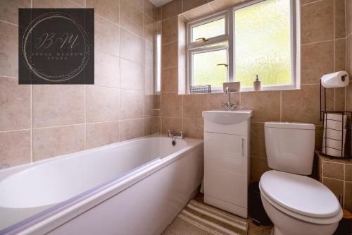 a bathroom with a tub and a toilet and a sink at Popular Contractor 2-Bed House in Lincoln in Lincoln