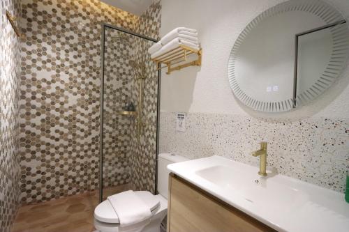 La salle de bains est pourvue de toilettes, d'un lavabo et d'un miroir. dans l'établissement Casabella 201 A2 Grand Batam Penuin Wet Market, à Nagoya