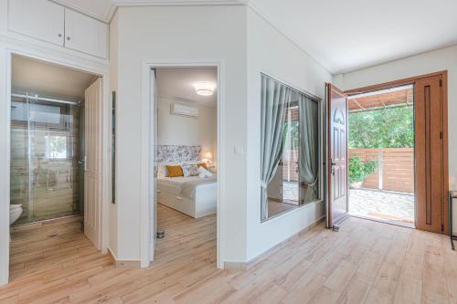 ein Wohnzimmer mit einem Bett und einer Glastür in der Unterkunft Paralio Astros Beachfront Suites in Xiropigado