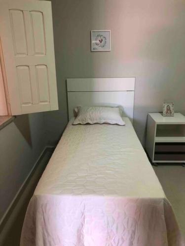 a small bedroom with a bed with a white bedspread at Apartamento A em Crato-Ce próximo ao centro in Crato
