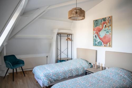 um quarto com 2 camas e uma cadeira em Chestnut House Appartment em Le Mée-sur-Seine