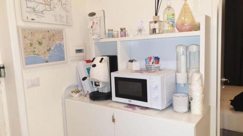 un microondas sentado en un estante en una cocina en F.Rooms Napoli, en Nápoles