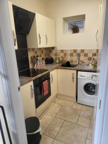 a small kitchen with a sink and a washing machine at Tarn Cottage in Skegness