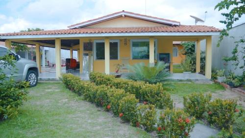 ein gelbes Haus mit einem davor geparkt in der Unterkunft Pousada Sitio Sossego dos Lençóis in Barreirinhas