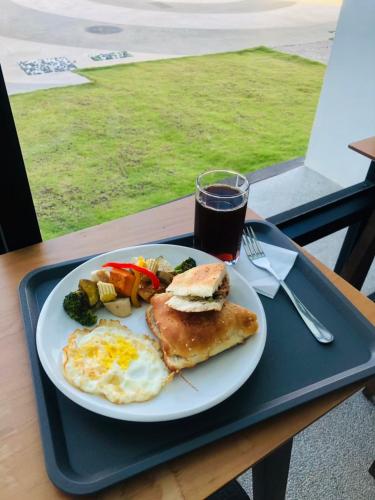 Een bord met ontbijtproducten op een dienblad, met een drankje erbij. bij SH Villa in Huxi