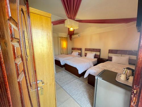 um quarto de hotel com duas camas e um lavatório em Sami Holiday Inn - pyramids view Rooftop no Cairo