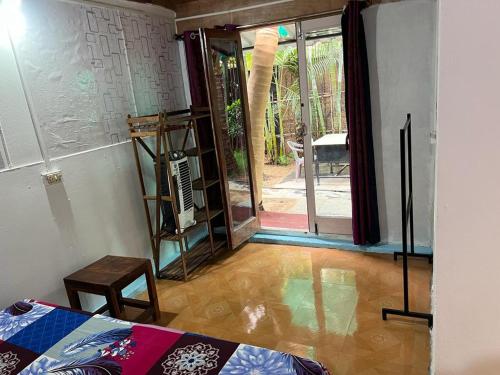 Zimmer mit einem Bett und einer Tür zu einer Terrasse in der Unterkunft Oceanic guest house in Canacona